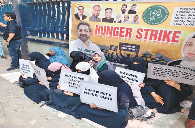 Advocates outside the college, along with female students, displaying placards